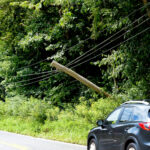 pole leans on power line